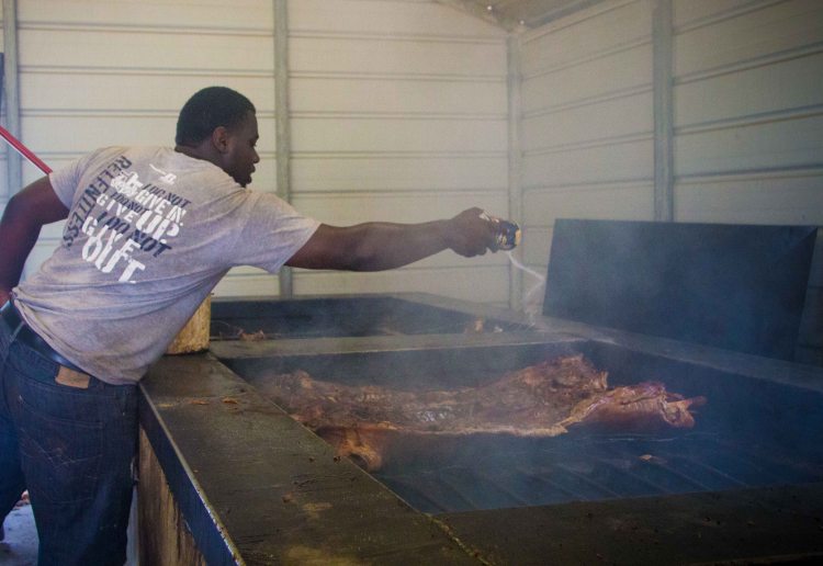 Seasoning the pig with what appears to be copious amounts of salt and other spices. I'm shocked at how much he's using, but then realize it's a 150lb pig he's seasoning.